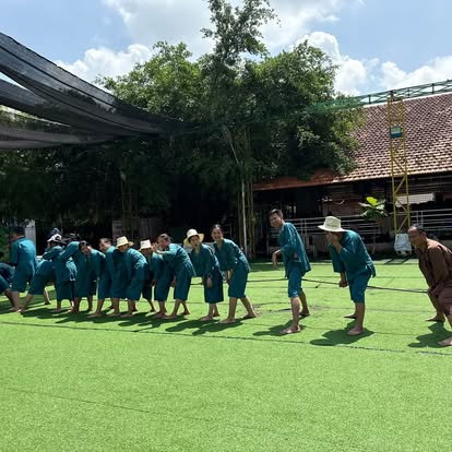 Đoàn khách áo xanh chơi kéo co trên sân cỏ tại Làng du lịch sinh thái Ông Đề